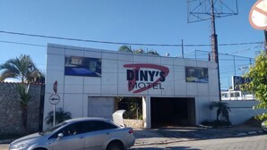 Un edificio con un letrero que dice 'Diny's Motel', con un logotipo rojo y negro.