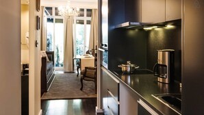 A modern kitchen with dark cabinetry, a stainless steel range hood, and a coffee maker. - DuCarmo Apartments Caves Vinho do Porto (Vila Nova de Gaia)