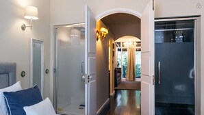 A hotel room with a bed, a glass door leading to a balcony, and a separate glass-enclosed shower area. - DuCarmo Apartments Caves Vinho do Porto (Vila Nova de Gaia)