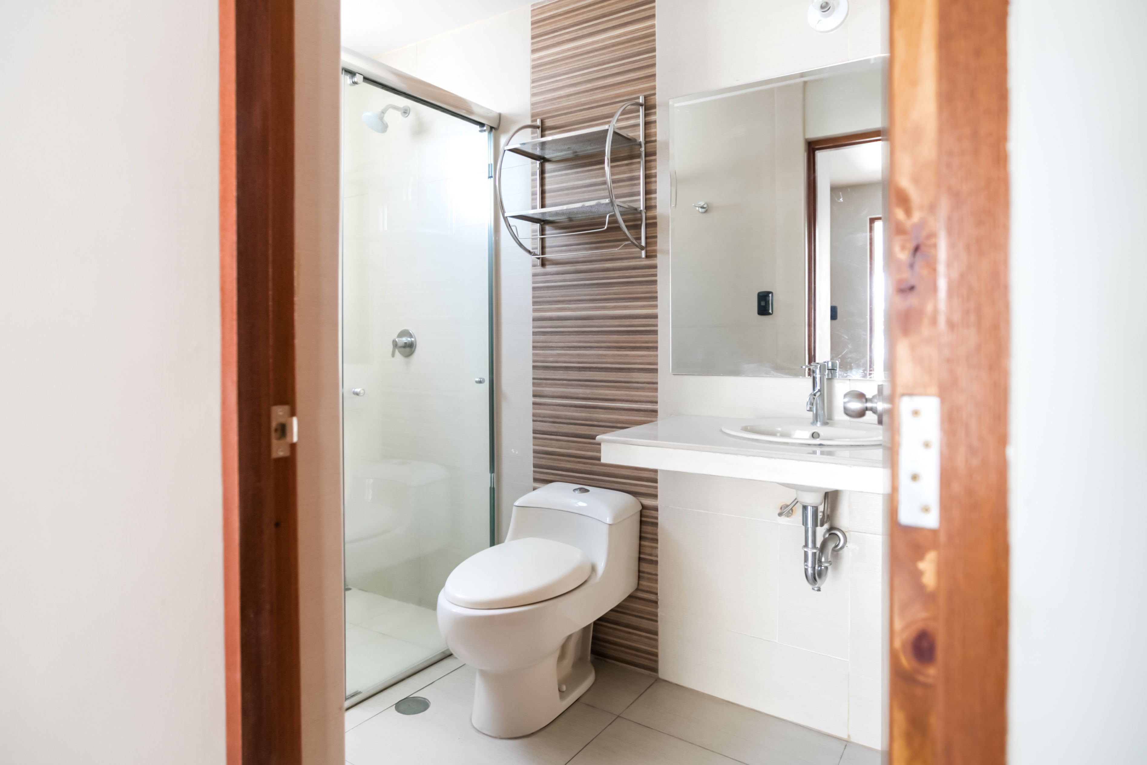 Une salle de bain moderne équipée de toilettes, d’une douche et d’un lavabo.