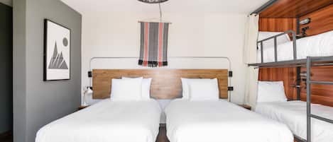 Quarto com duas camas de solteiro, uma cama beliche, um lustre pendurado e um quadro na parede.
