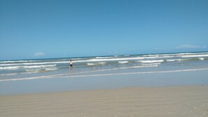 Una playa con olas y un cielo despejado.
