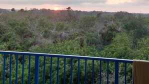 Ein Balkon mit Blick auf eine natürliche Landschaft im Abendlicht.