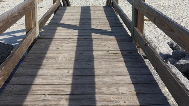 A wooden boardwalk leading to a sandy beach with the ocean in the background. - Short walk to beach or Pier Village, We consider FLETC (Saint Simons Island)