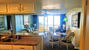 A kitchen with a dining area, a ceiling fan, and a view of the outdoors. - OCEAN FRONT Classy, Beachy Double Balcony Condo #306 at Cape Winds Resort (Cape Canaveral)