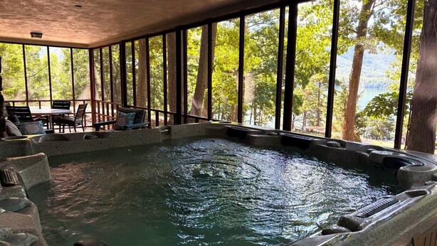 Un jacuzzi con vistas a árboles y un lago.