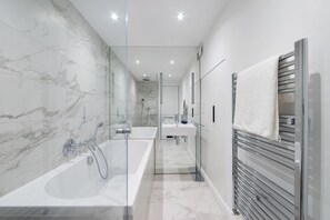 Bathtub, hair dryer, towels, shampoo