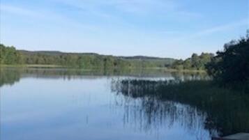 Un llac tranquil amb un moll de fusta que s'endinsa a l'aigua.