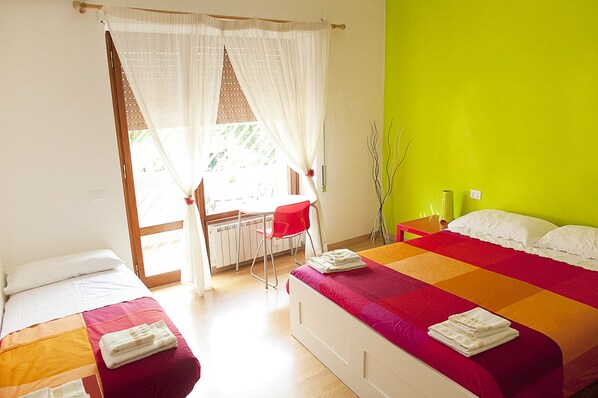 A hotel room with a bed, a desk, and a chair.