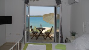A bedroom with a balcony overlooking a beach. - Villa Danica - Apartment (studio) 2 persons - direct at sea - 4 star (Betina)