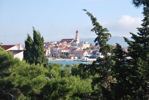 A coastal town with a prominent church tower, surrounded by residential buildings and a body of water. - Villa Danica - Apartment (studio) 2 persons - direct at sea - 4 star (Betina)