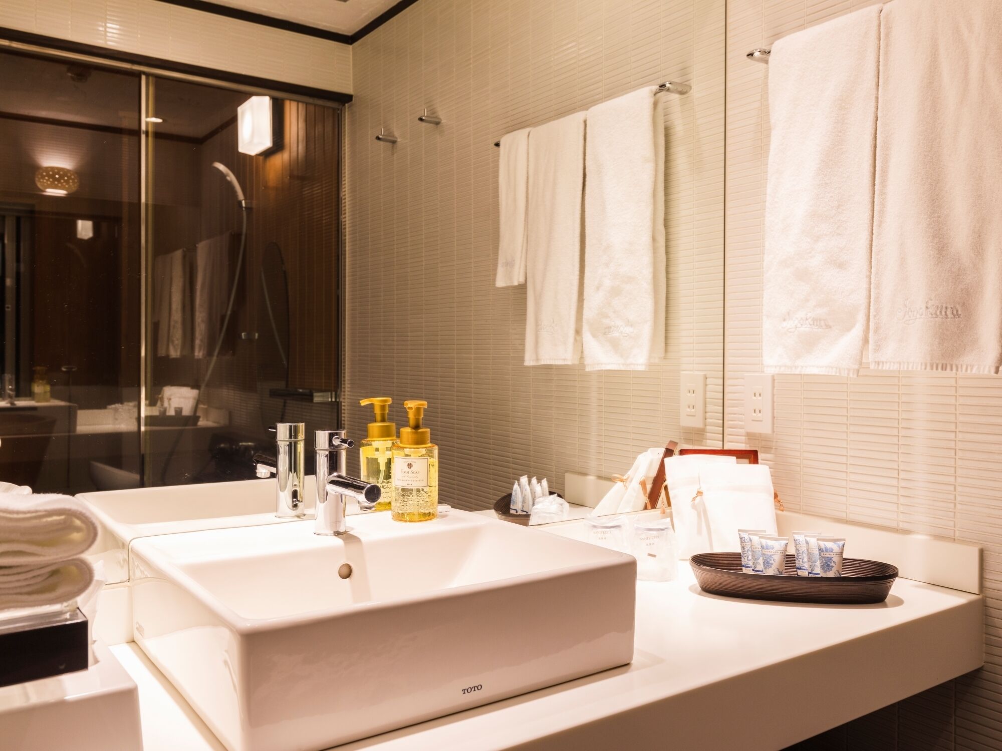 Un bagno moderno con un lavandino grande, uno specchio e una cabina doccia in vetro.
