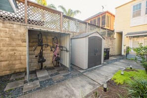 Ein Wohngebiet mit Garage, Fahrradständer und einer kleinen Gartenhütte.