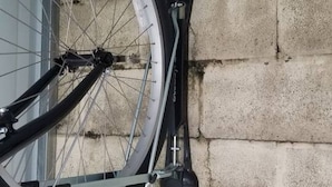 A bicycle leaning against a concrete wall.