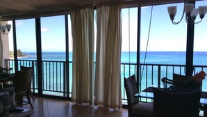 A room with a view of the ocean, large windows, and a dining area with chairs and a table. - Best Kept Secret on Oahu ! (Waiʻanae)