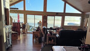 A spacious room with large windows, a wooden ceiling, and a treadmill. - Hayward, Wisconsin Waterfront Cabin located on Nelson Lake, Pontoon available. (Hayward)