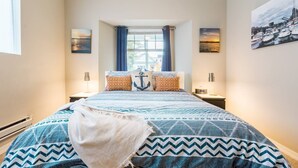 A bedroom with a bed, a window with curtains, and two wall-mounted lamps. - Urban Retreat! Sauna-Updated Craftsman Private Backyard! Pet friendly! Discounts (Seattle)