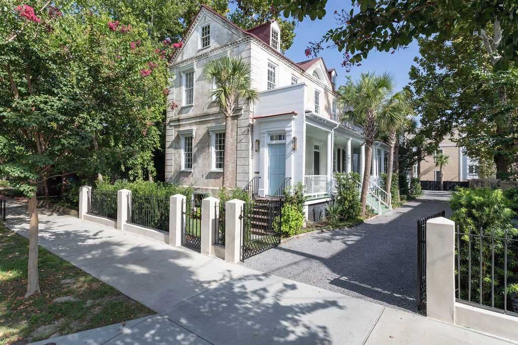 A two-story house with a front porch and a driveway leading to the entrance.