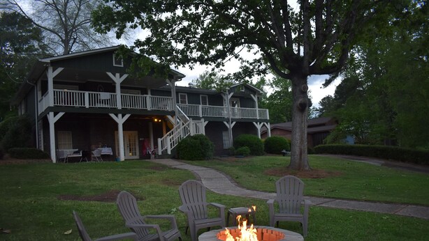 A two-story house with a porch, outdoor seating, and a fire pit. - Fishing Tournaments, Auburn Games (Alexander City)