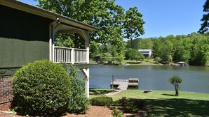 A lakeside property with a covered porch, a dock, and a small boat. - Fishing Tournaments, Auburn Games (Alexander City)