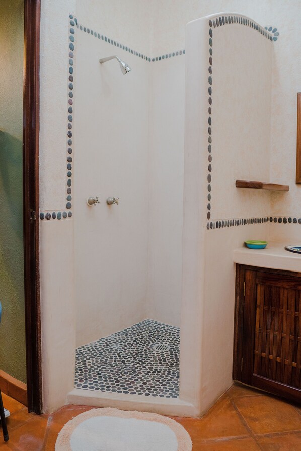 A shower with a tiled floor and a decorative border.