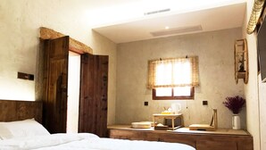 A bedroom with a large bed, a wooden door, a small table with a pitcher, and a window with curtains. - Kinmen redbrick houses across Hope (Xiamen)