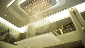 A modern interior with a large, illuminated ceiling feature and a reflective floor. - Mercure Harbin Songbei (Harbin)