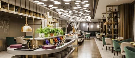 A modern restaurant with a curved counter, multiple seating areas, and a ceiling with circular lights.