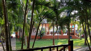 Un espacio al aire libre cubierto con una terraza de madera y vistas a un edificio de fachada roja y blanca.