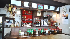 A bar area with shelves of bottles, jars of condiments, and a clock on the wall.