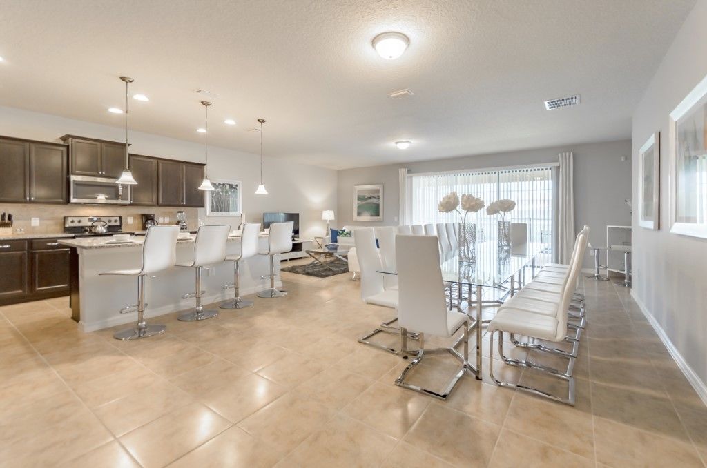 A modern kitchen with dark cabinets, a central island, and pendant lighting.