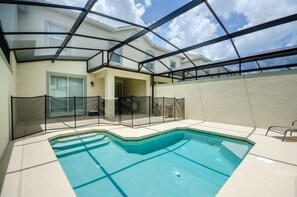 A swimming pool with a glass enclosure, surrounded by a white wall and a balcony with a glass railing. - Ev230259 - Champions Gate Resort - 4 Bed 3 Baths Townhome (Davenport)