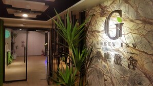 A hotel entrance with a marble wall and a logo. - Greeninn Hotel (New Taipei City)