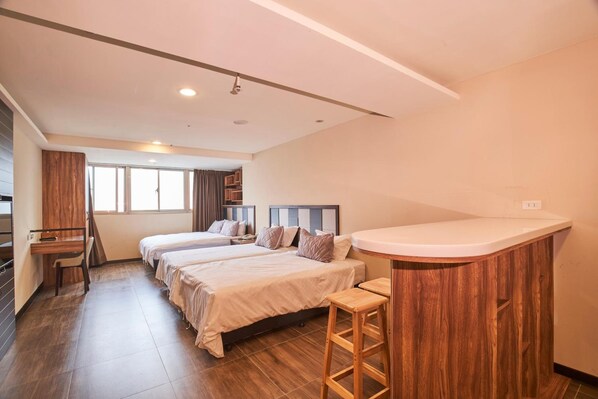 A hotel room with two beds, a desk, a small kitchenette, and a large window. - Greeninn Hotel (New Taipei City)