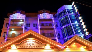 Un hotel con fachada tradicional, varios balcones y una entrada bien iluminada.