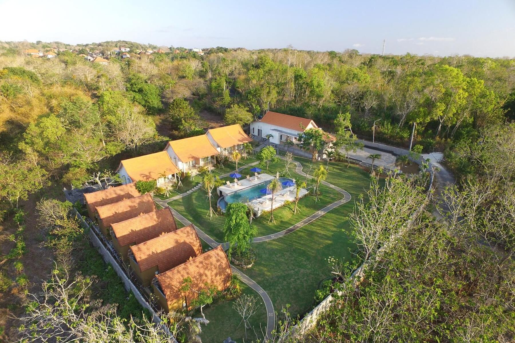 A residential area with multiple houses, a swimming pool, and a well-maintained lawn.
