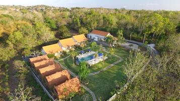A residential area with multiple houses, a swimming pool, and a well-maintained lawn.