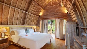 Una habitación de madera con una cama grande, vigas de madera en el techo y vistas al exterior.