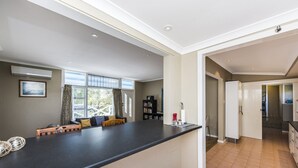 A modern kitchen with a black countertop, a built-in oven, and a refrigerator. - Blueshack - Walking distance to foreshore (Guilderton)
