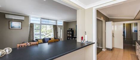 A modern kitchen with a black countertop, a built-in oven, and a refrigerator.