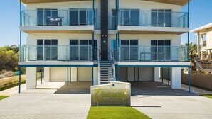En modern byggnad med flera våningar, glasbeklädda balkonger, en central trappa och en skylt med texten ”Ocean”.