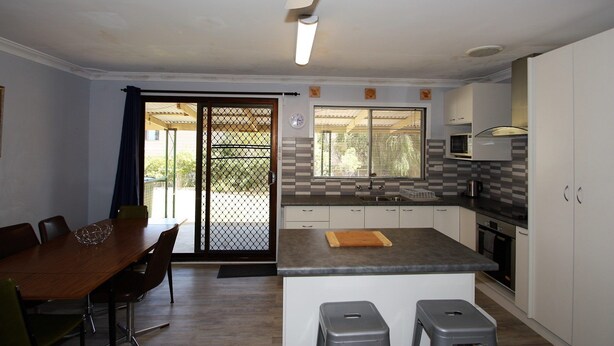 A compact kitchen with a dining area, a microwave, and a sink.
