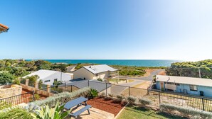 A coastal residential area with houses, a clear blue sky, and a view of the sea. - Ocean View Retreat - Best Views in town (Guilderton)