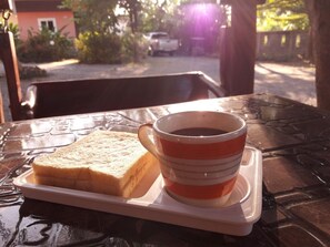 Ett fat med en skiva rostat bröd och en kopp kaffe på ett bord.