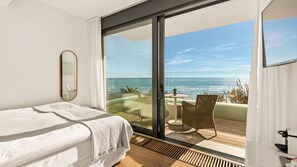 Enjoy ocean views from the balcony with a wicker chair and small table.