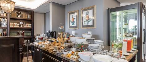 A modern kitchen with a marble countertop, various food items, and a glass display case.