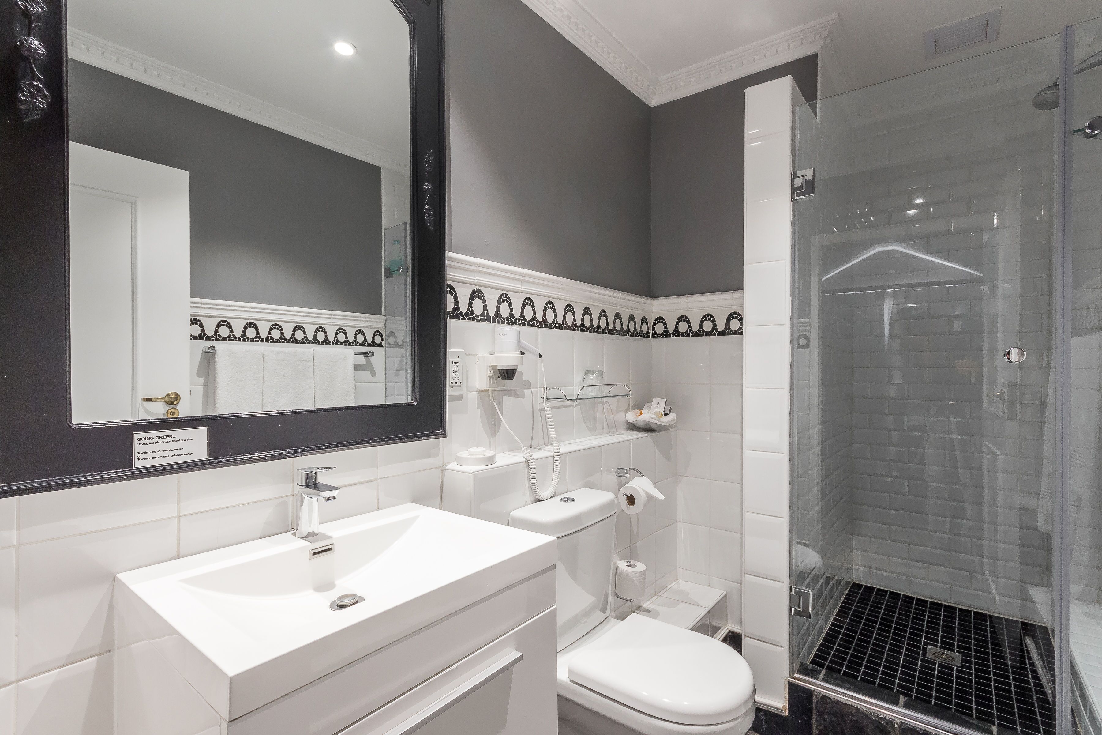 A modern bathroom with a white sink, toilet, and shower.