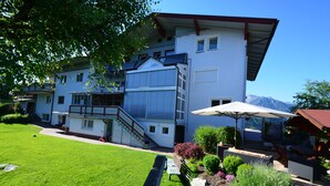 Un bâtiment à deux étages doté d’un balcon, d’un escalier et d’une pelouse bien entretenue.