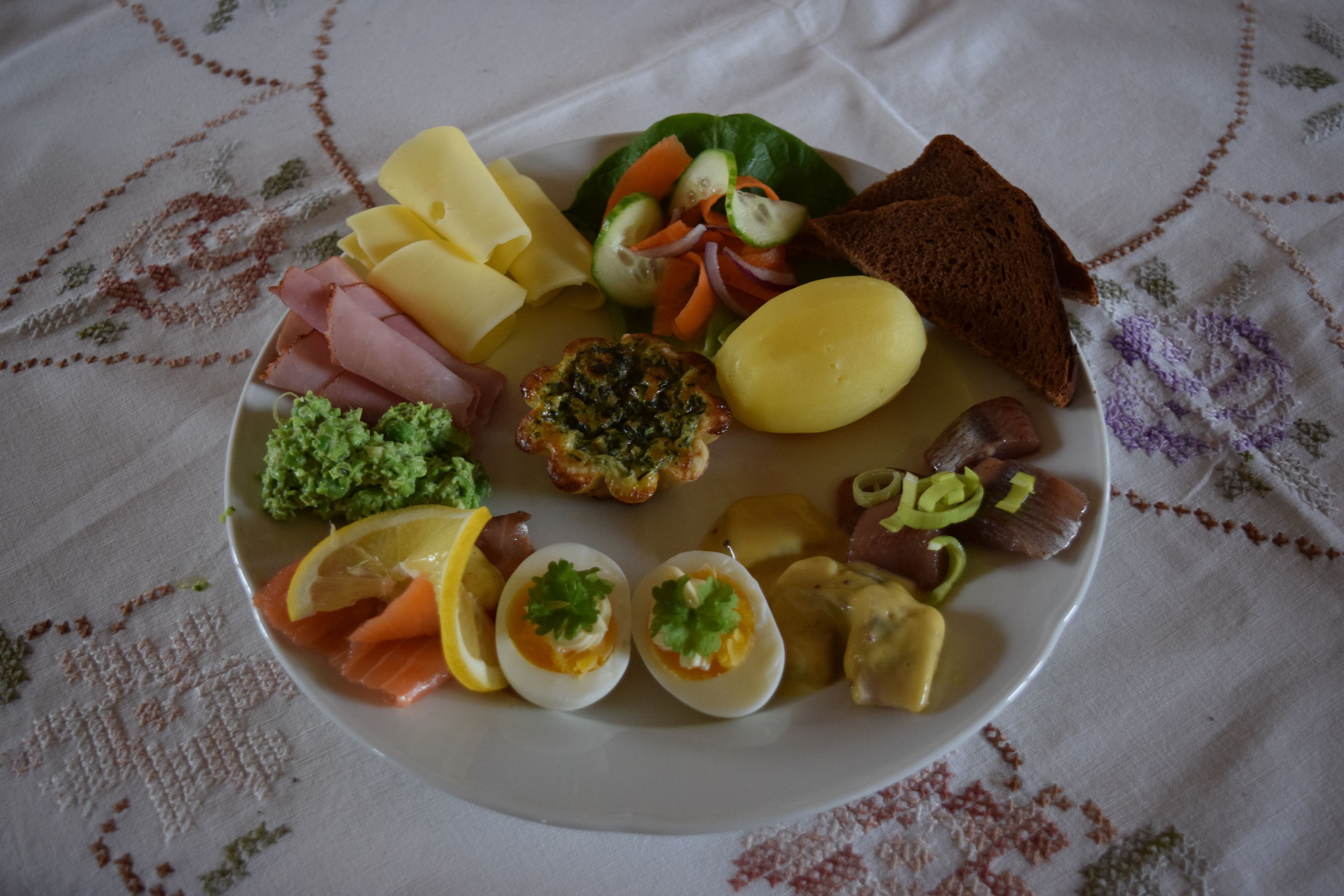 Um prato com diversos alimentos, incluindo queijo, presunto, ovos e legumes.