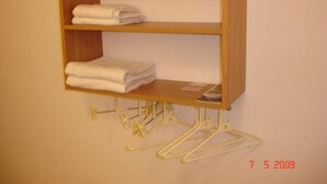 Ein Holzregal mit gefalteten Handtüchern und Kleiderhaken.